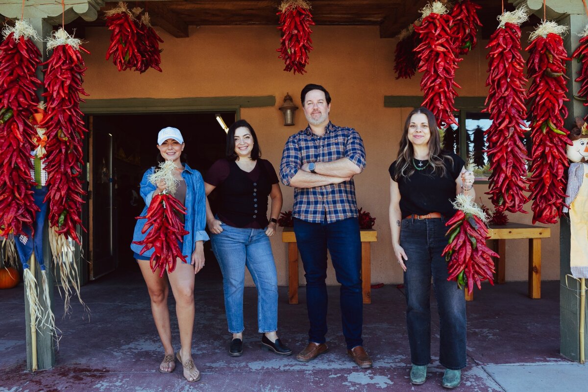 The Better with Baron team standing outside Wagner's Farm in Corrales, surrounded by hanging red chile ristras.