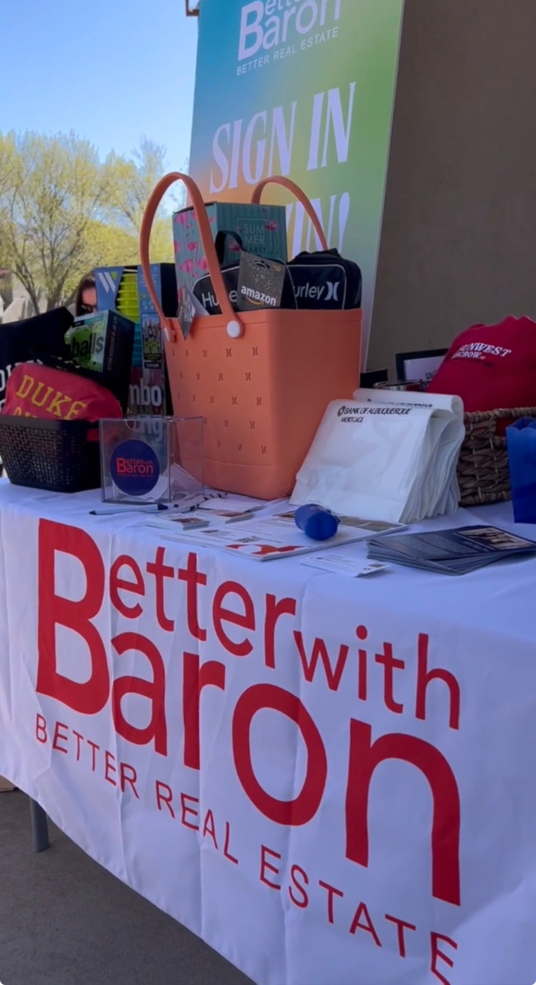Close-up of the Better with Baron sign-in-to-win prize table at a New Mexico community event