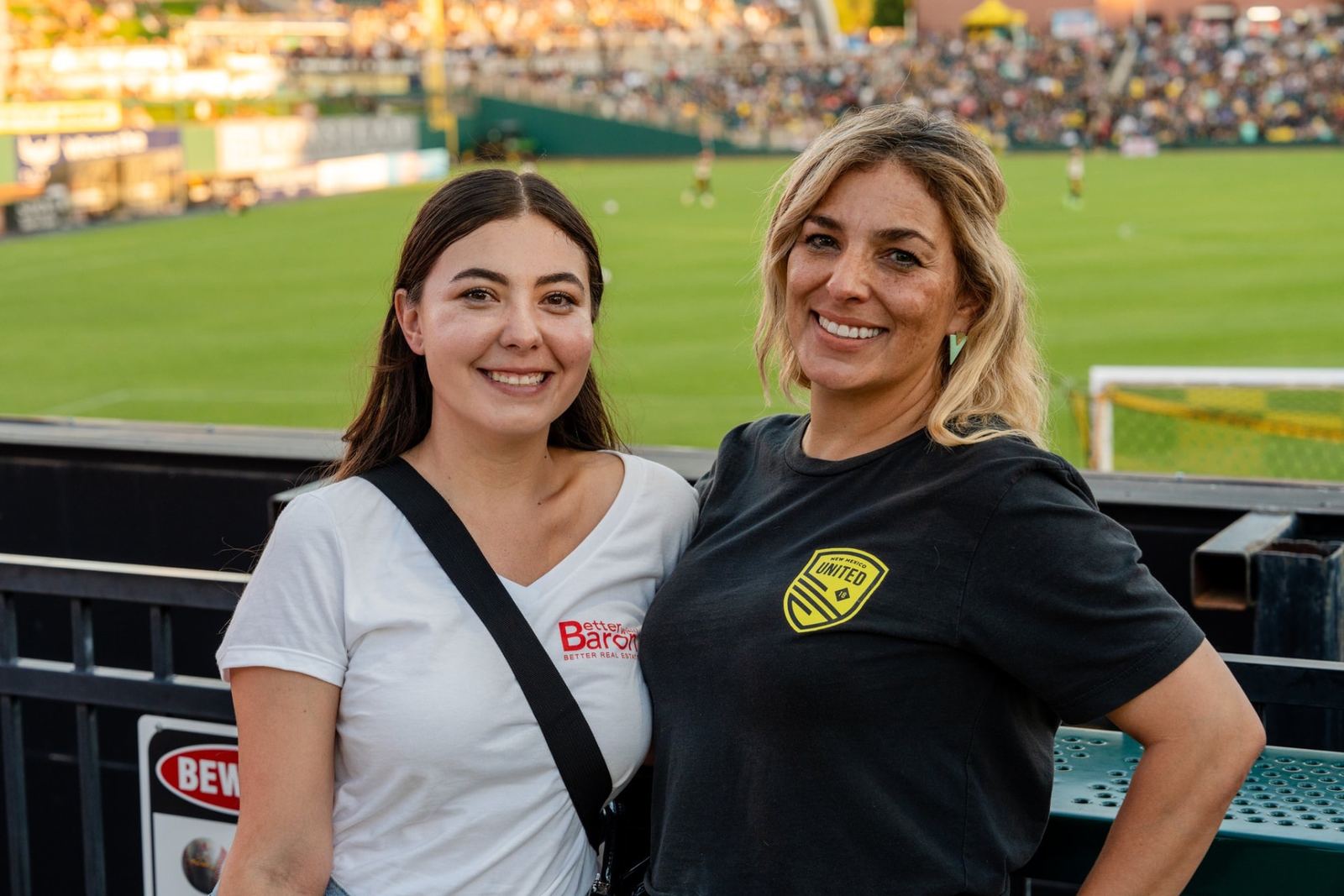 Better with Baron team member and client in New Mexico United gear at a Better with Baron client event in Albuquerque.