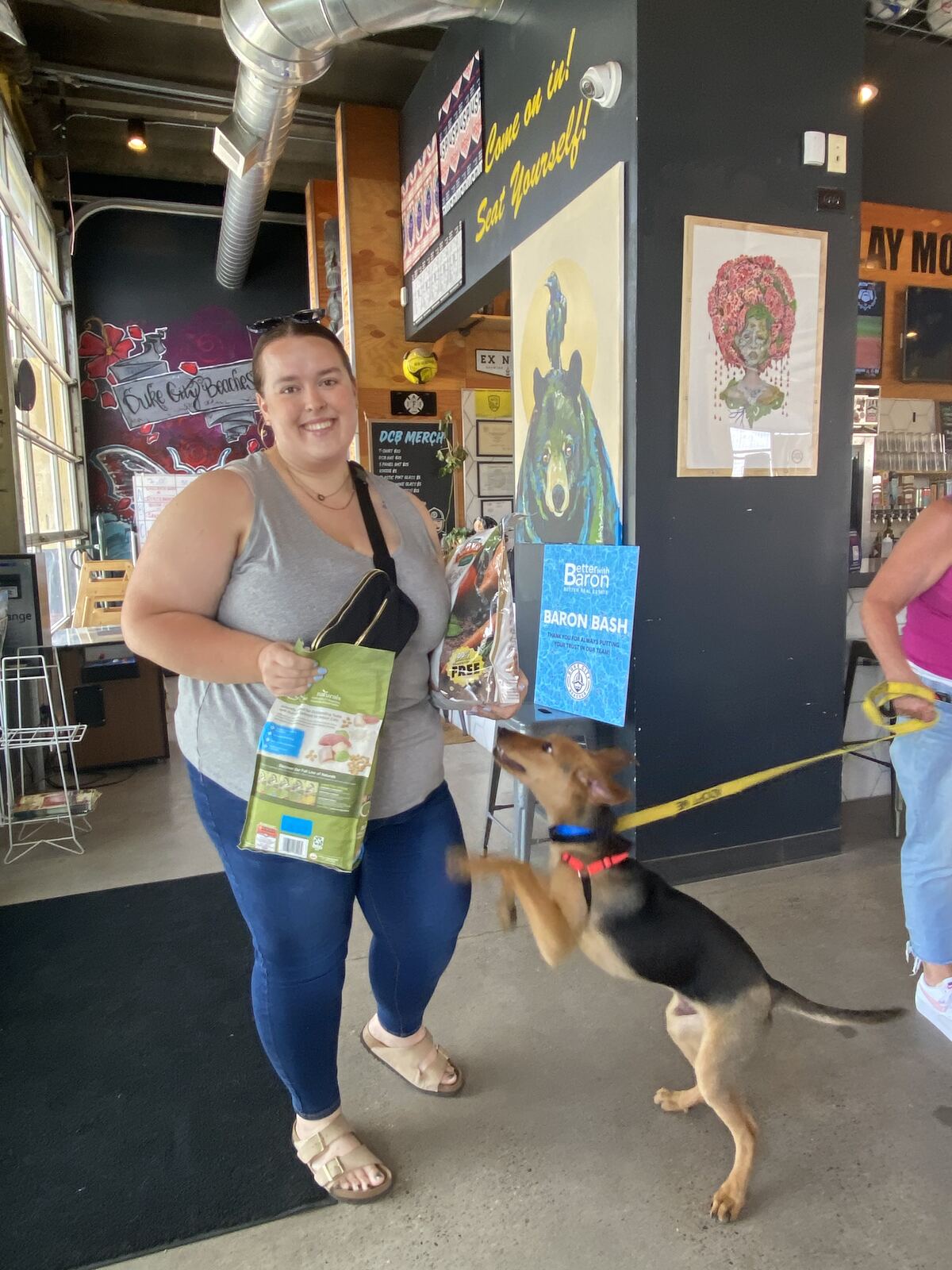 Guest and rescue dog with donated pet food at the Better with Baron Baron Bash benefiting Animal Humane New Mexico