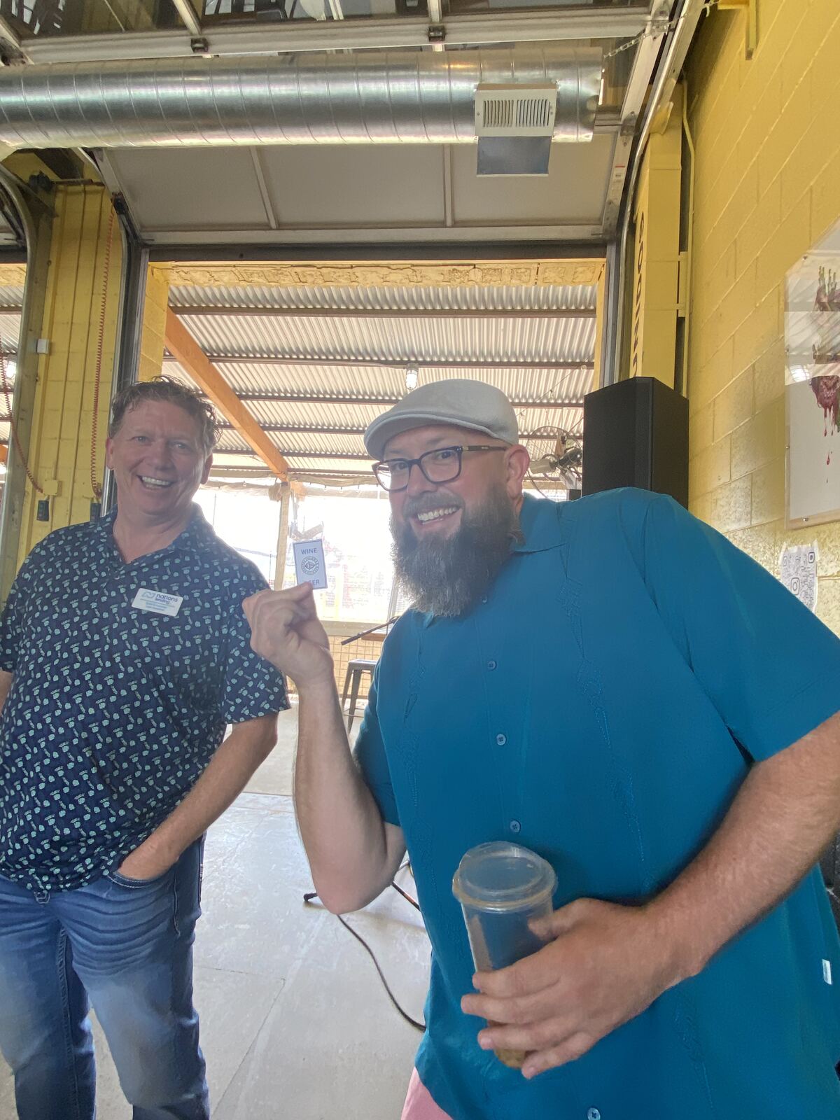 Better with Baron team members laughing with a drink token at the Baron Bash client party in Albuquerque