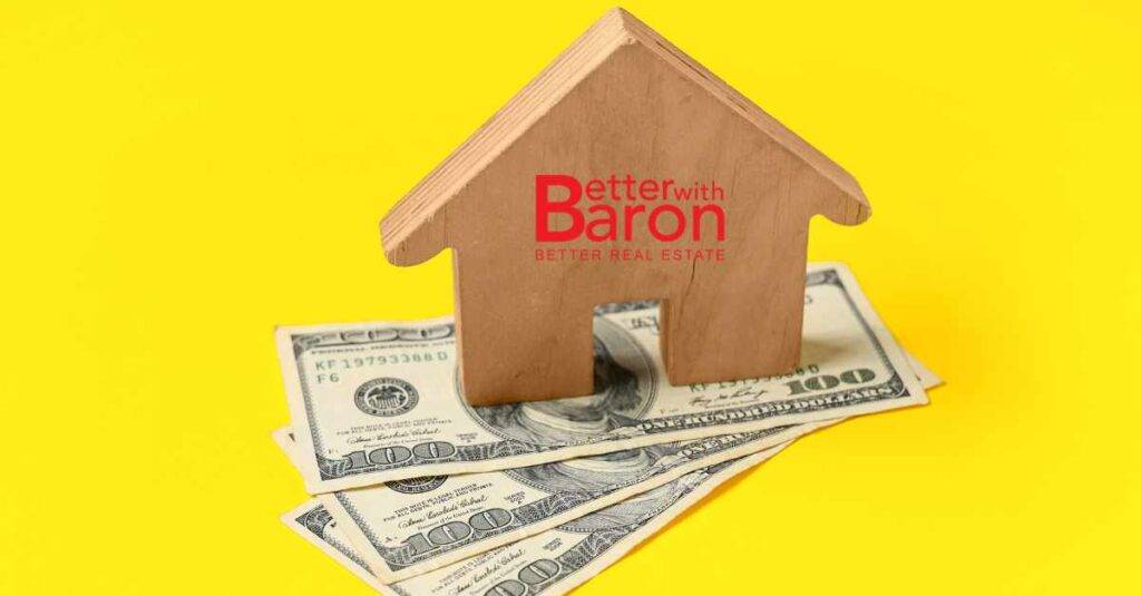 A small wooden home with the Better with Baron logo on top of three 100 dollar bills underneath. Seller financing Albuquerque.