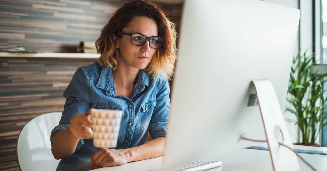 What credit score do I need to buy a home in Albuquerque. Women with a cup of coffee looking at her credit score on a computer.