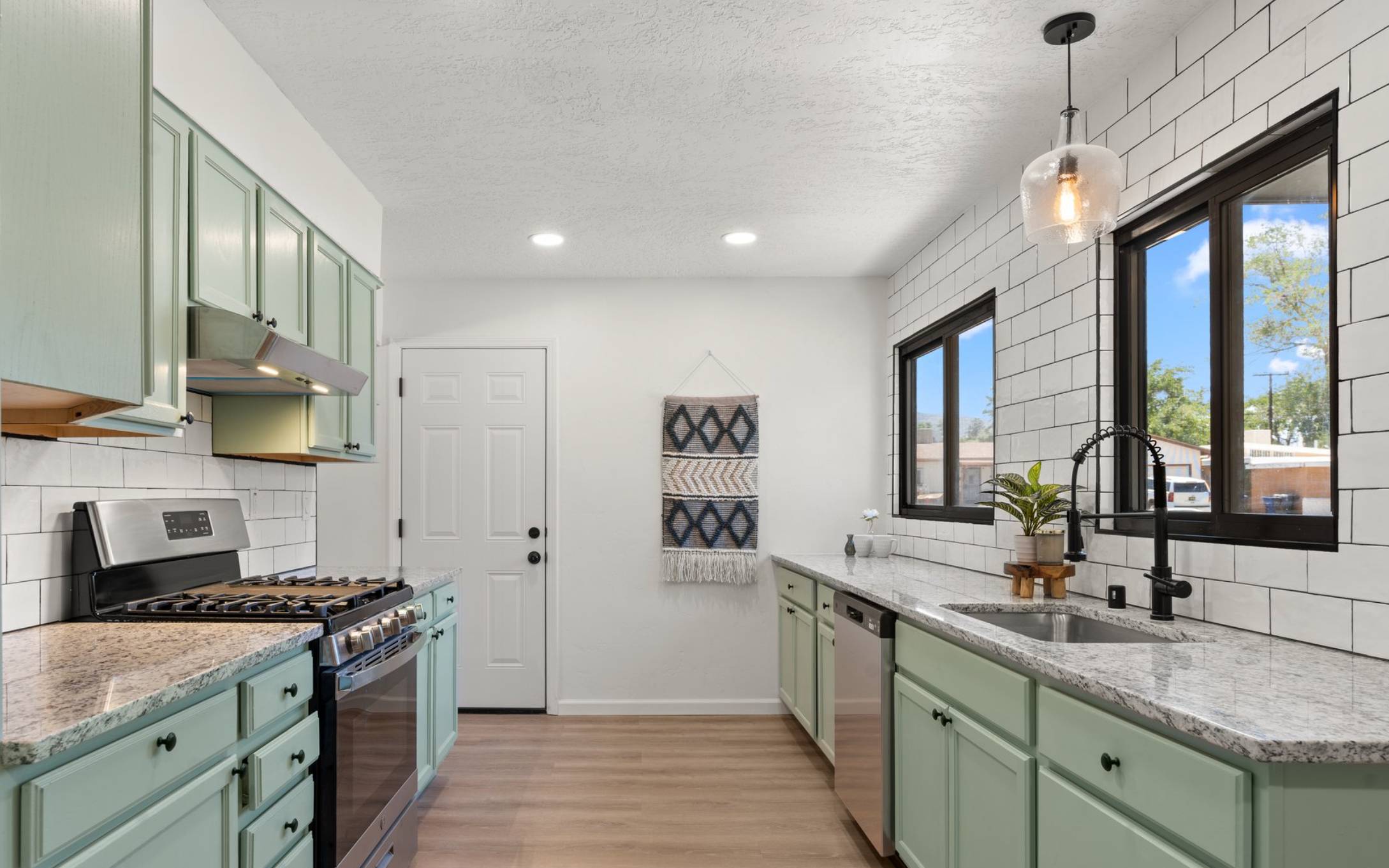Newly renovated kitchen with mint green cabinets and white subway backsplash. Should You Sell Before Buying in Albuquerque? 