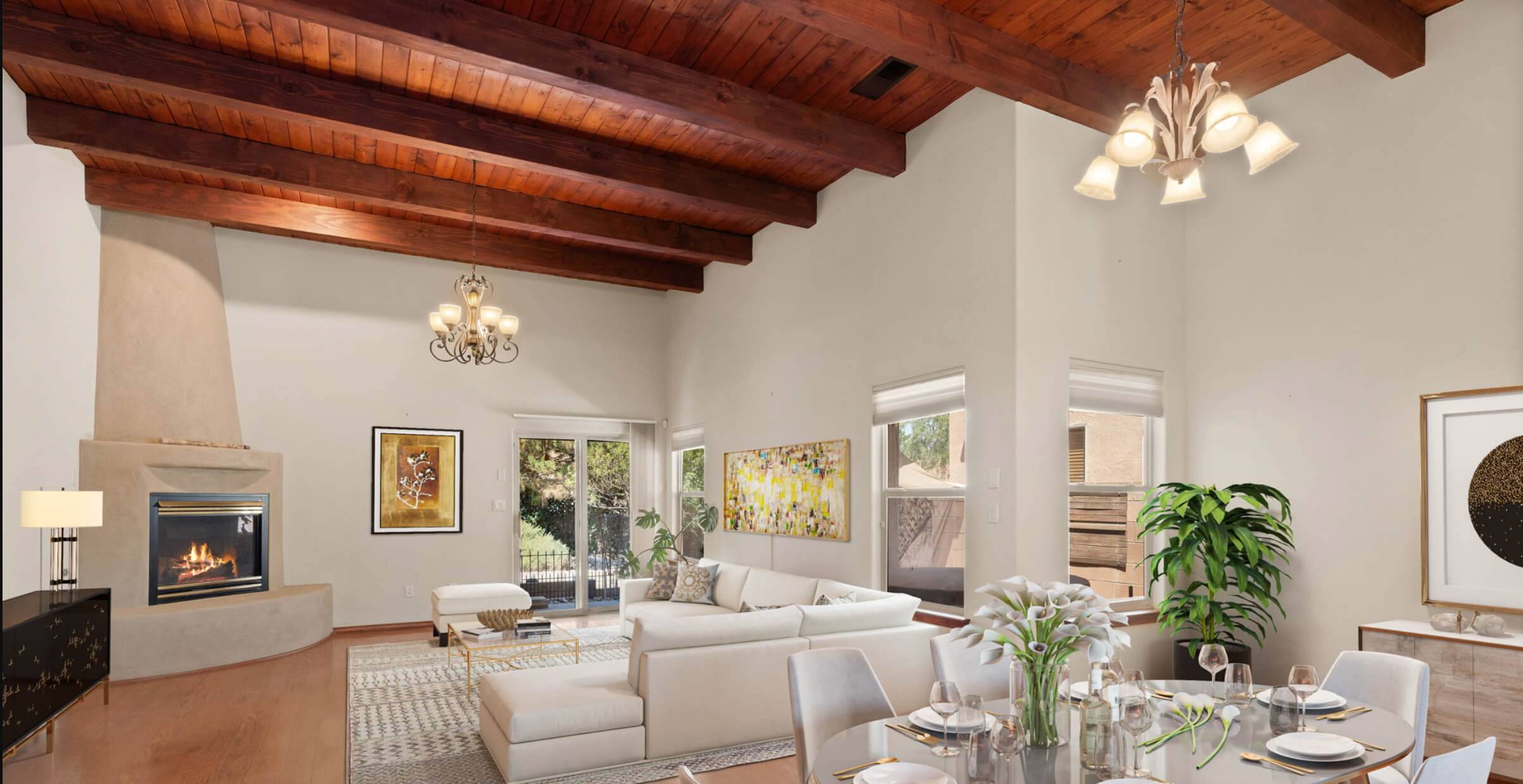 Open dining room and living room with wooden beams on the ceiling and a beautiful Kiva fireplace. Best time to sell a house in Albuquerque