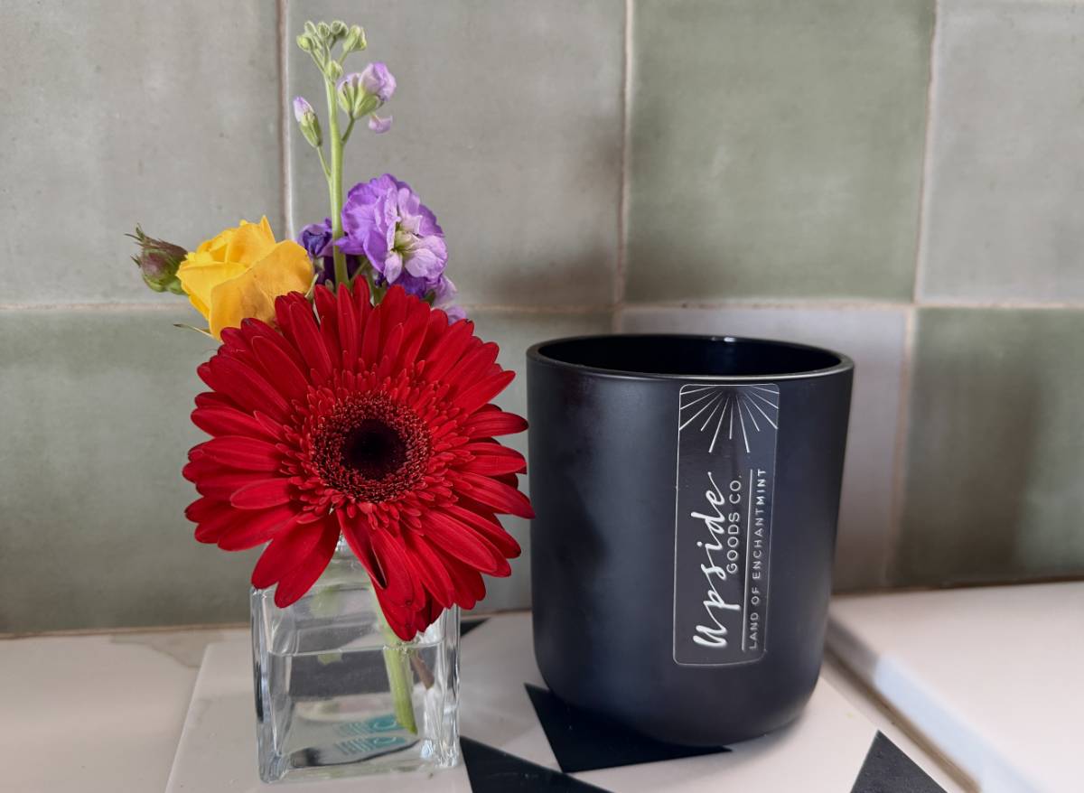 Upside Goods Co candle in a kitchen with flowers.